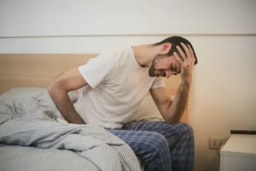 a man experiencing a headache after waking up