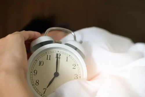 a person looking at the alarm clock.