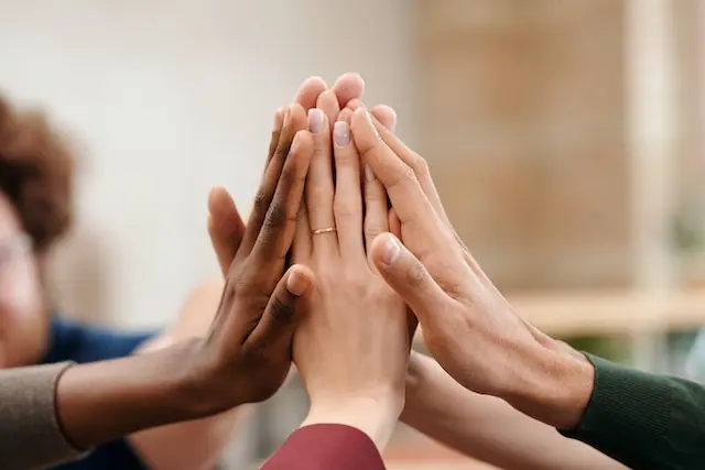 People touching their hands in support