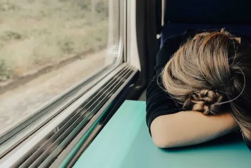 girl sleeping on a train depicts how important managing burnout is