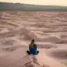Woman sitting on a dune.