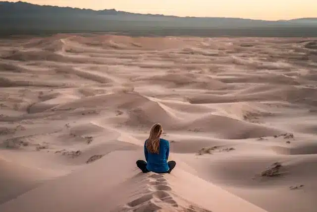 Woman sitting on a dune.