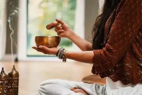 Woman in a brown sweater in a meditation ritual.