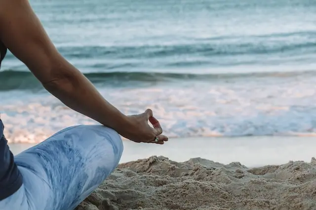 person meditating by the ocean