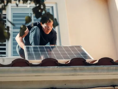 a man installing a solar panel on a roof for home improvement