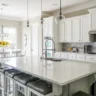A big kitchen with a white table, countertops and shelves.