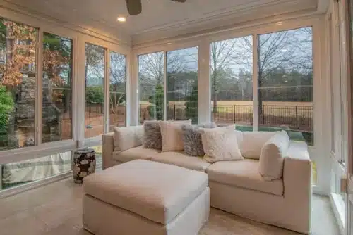 Beige couch with pillows near large windows