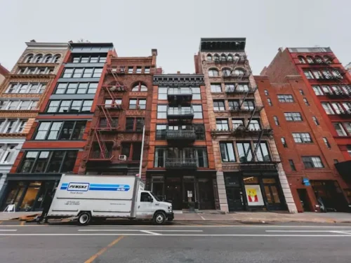 White moving truck in front of New York buildings