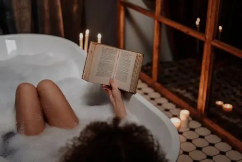 A person reading a book in a bathtub