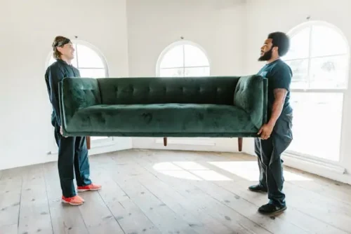 two men carrying a sofa and helping you streamline your belongings before the move