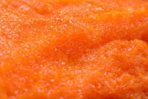 Close up of ripe papaya flesh showing soft juicy orange texture and natural tropical fruit pulp