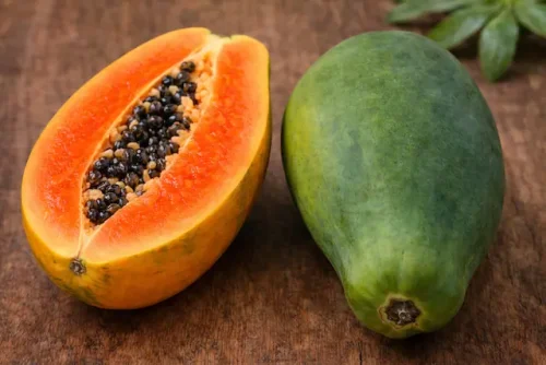 Comparison of ripe orange papaya and green unripe papaya showing differences in color texture and ripeness