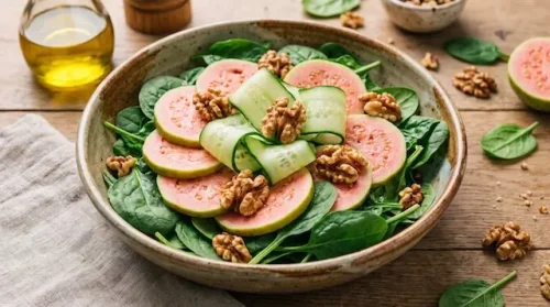 Can diabetics eat guava in daily meals? A fresh spinach salad topped with raw pink guava slices and walnuts.